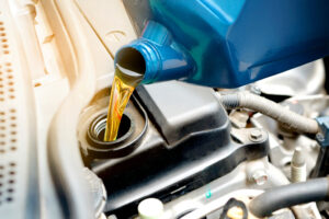Pouring oil into car engine. Oil change concept.