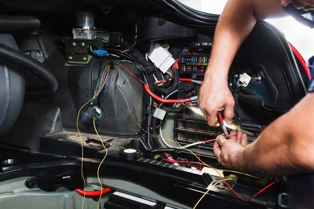 Car mechanic working on vehicle electronics