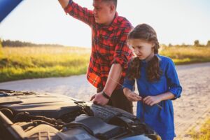 dad and daughter check car engine